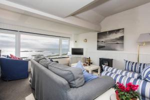 a living room with blue and white furniture and a large window at HEADLANDS-2 BED-SEA VIEW APARTMENT-TREARDDUR BAY in Trearddur