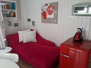 a red couch in a room with a red refrigerator at Haus Wiedersehen, Mischabel (2-Zi) in Saas-Grund