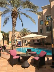 a palm tree sitting next to a swimming pool at Holiday Inn Al Khobar, an IHG Hotel in Al Khobar