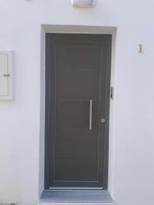 una porta nera sul lato di un edificio di Smyrnis Apartments a Ermoupoli