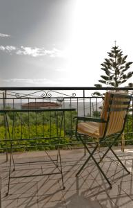 カルダミリにあるSkardamoula's Studios n Apartmentsの椅子(テーブルの上に座るバルコニー付)