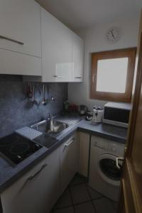 a kitchen with white cabinets and a sink and a window at Villa Ula Verda- Apartments Marianna in Santa Cristina in Val Gardena