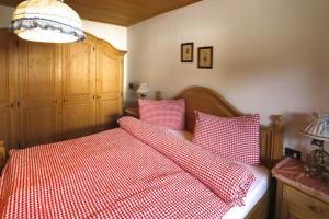 a bedroom with a bed with red and white sheets at Villa Ula Verda- Apartments Marianna in Santa Cristina in Val Gardena