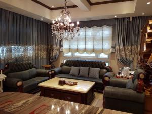 uma sala de estar com sofás e um lustre em Loving kinmen Homestay em Jincheng