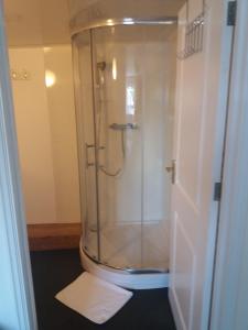 een douche met een glazen deur in de badkamer bij The Maidens Chambers in Canterbury
