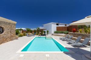 una piscina con sedie e una casa di Trialonia Luxury Villa a Kíssamos
