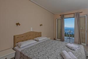 a bedroom with a bed and a view of the ocean at eleni studios in Vlachata