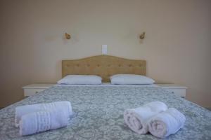 a bedroom with a bed with towels on it at eleni studios in Vlachata
