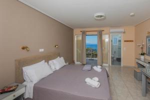 a bedroom with a bed with towels on it at eleni studios in Vlachata