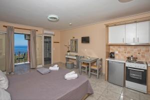 a living room with a kitchen and a table at eleni studios in Vlachata