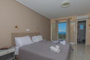 a bedroom with a bed with towels on it at eleni studios in Vlachata