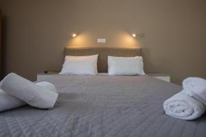 a bedroom with a bed with towels on it at eleni studios in Vlachata