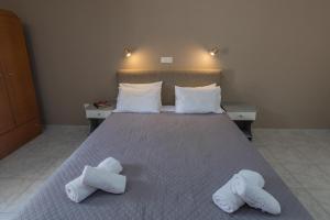 a bedroom with a bed with towels on it at eleni studios in Vlachata
