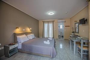 a bedroom with a bed and a bathroom with a sink at eleni studios in Vlachata