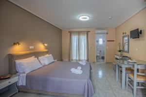 a bedroom with a bed with a stuffed animal on it at eleni studios in Vlachata