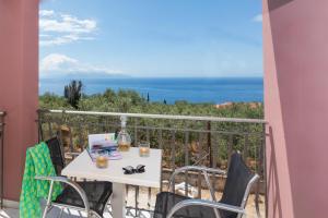 a table on a balcony with a view of the ocean at eleni studios in Vlachata