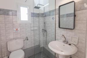 a bathroom with a sink and a toilet and a mirror at eleni studios in Vlachata