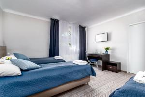 ein Hotelzimmer mit 2 Betten und einem Schreibtisch in der Unterkunft JACHTOWA Hotel i Restauracja in Stettin