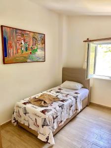 1 dormitorio con 1 cama y una pintura en la pared en Gera Apart Phantaso, en Kemer