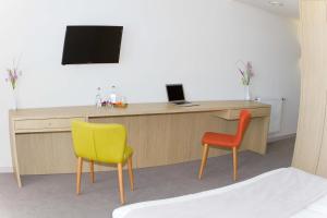 a desk with two chairs and a laptop on it at Bourquin Hotel - Lycée Hôtelier Christian Bourquin in Argelès-sur-Mer