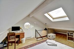 a attic room with a bed and a desk and a window at House Perigourdine ex former diligence relay in Falgueyrat