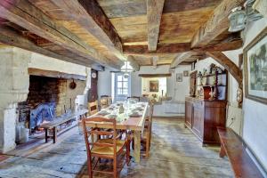 a dining room with a table and a fireplace at House Perigourdine ex former diligence relay in Falgueyrat