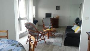 uma sala de estar com um sofá, uma mesa e cadeiras em Les Trinitaires em Sarzeau