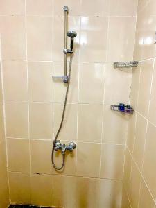 a shower with a hose in a tiled bathroom at Gera Apart Flora in Kemer