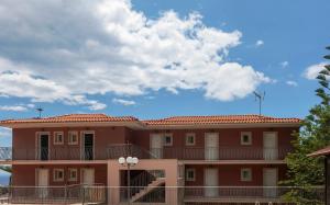 a large red building with a blue sky and clouds at eleni studios in Vlachata