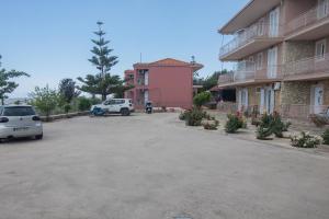 a parking lot in front of a pink building at eleni studios in Vlachata