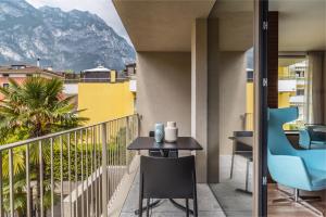 uma varanda com uma mesa e cadeiras e uma montanha em ESSENCE - Charming Suites em Riva del Garda