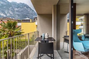a balcony with a table and chairs and a mountain at ESSENCE - Charming Suites in Riva del Garda