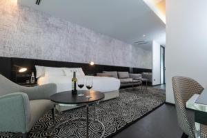 a hotel room with a bed and wine glasses on a rug at NYX Herzliya in Herzliya