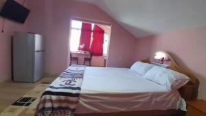 a bedroom with a large bed and a refrigerator at Guest House Pogradeci in Pogradec