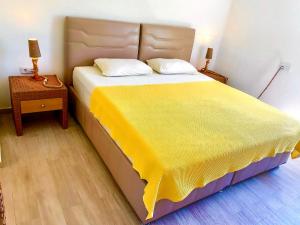 1 dormitorio con 1 cama grande con manta amarilla en Gera Apart Adonis en Kemer