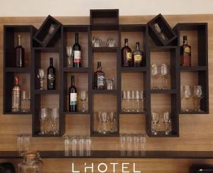 a bunch of wine glasses and bottles on a shelf at L'Hotelpz in Prizren