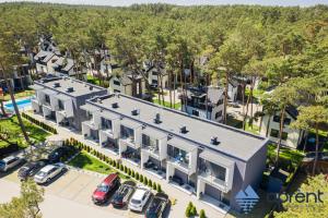 an aerial view of a building with cars parked in a parking lot at Apartament MALIBU - Aprent in Pobierowo