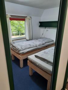 mały pokój z 2 łóżkami i oknem w obiekcie Ferienhaus Eichenblatt w mieście Werder