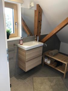 a bathroom with a sink and a staircase with a window at mama käthe - Apartments in Nenzing