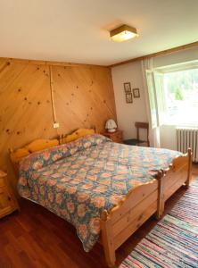 マドンナ・ディ・カンピリオにあるCasa Gatta 3 Camere 1 Bagno con vistaの木製の壁のベッドルーム1室(ベッド1台付)