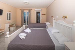 a bedroom with two beds with towels on them at eleni studios in Vlachata