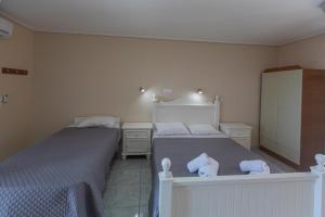 a bedroom with two beds and two night stands at eleni studios in Vlachata