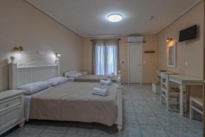 a hotel room with two beds and a desk at eleni studios in Vlachata