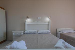 a bedroom with two beds with towels on them at eleni studios in Vlachata