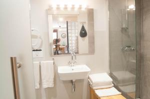 a white bathroom with a sink and a shower at Apartamentos de la Parte Antigua de Cáceres in Cáceres +104 photos