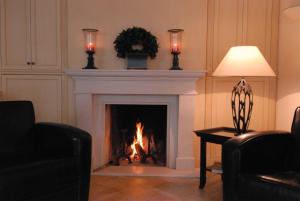 a living room with a fireplace with two candles at Strandhotel Fontana in Timmendorfer Strand
