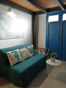 Sofá verde en una habitación con puerta azul en B&B Sea Salt en Terrasini Favarotta