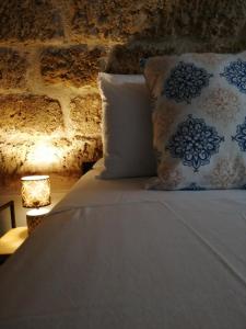 a bedroom with a bed with pillows and a lamp at B&B Sea Salt in Terrasini