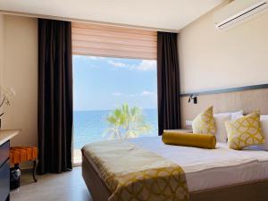 a bedroom with a bed with a view of the ocean at Zest Exclusive Hotel & Spa in Ortakent