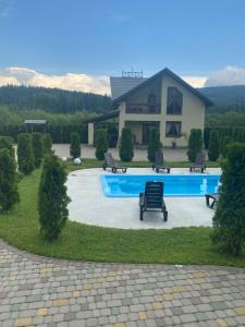 a house with a swimming pool in front of a house at VIP House in Mykulychyn